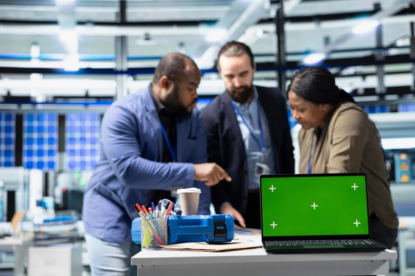 На солнечной электростанции сотрудники проводят мозговой штурм с демонстрационным макетом, вырабатывая решения.